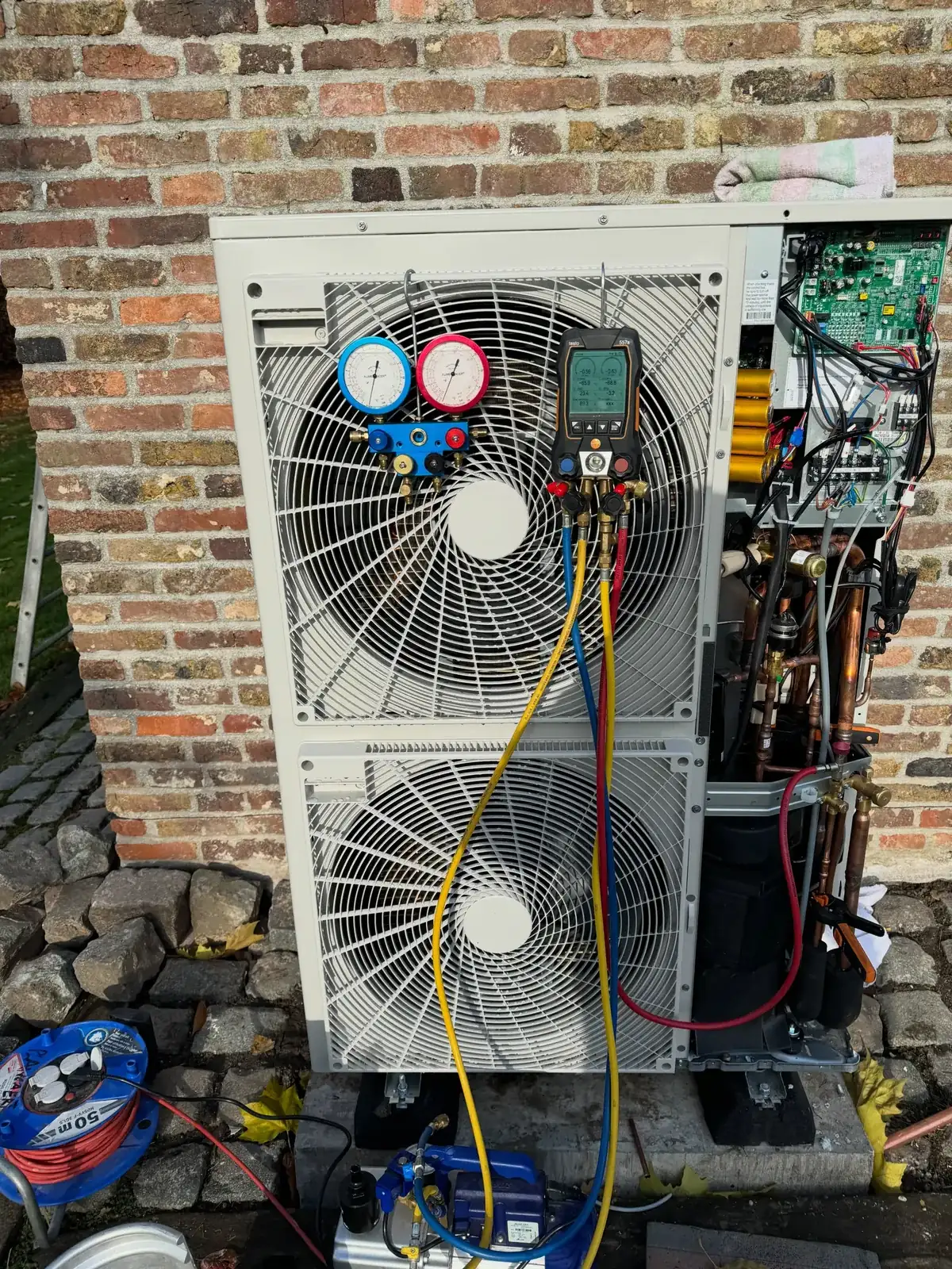 Onderhoud aan een airco-buitenunit met manometerset